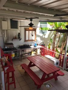 una cocina con una mesa de picnic roja en un patio en Toda la casa: 3 dormitorios, 4 baños y 1 futón., en Arecibo