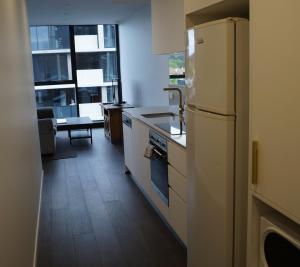 a kitchen with a white refrigerator in a room at Smart apartment right in Canberra CBD in Canberra
