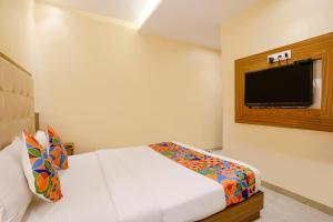 a bedroom with a bed and a flat screen tv at FabExpress Wynd in Mumbai