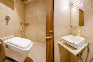 a bathroom with a toilet and a sink and a shower at FabExpress Wynd in Mumbai