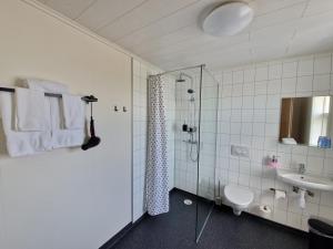 a bathroom with a shower and a toilet and a sink at Guesthouse Mikael in Höfn