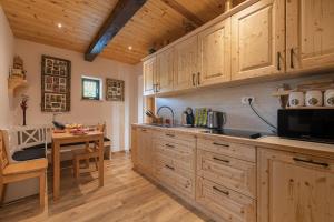 uma cozinha com armários de madeira e uma mesa em Vineyard Cottage Grajska Kašča - Happy Rentals em Mirna
