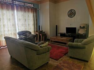 un soggiorno con 2 divani e una TV di Cheerful 3 Bedroom house with ample parking space. a Kampala