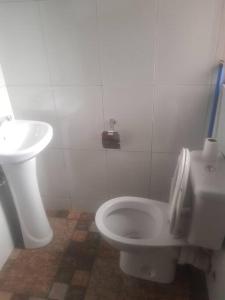 a bathroom with a toilet and a sink at Cheerful 3 Bedroom house with ample parking space. in Kampala +8 photos