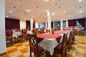 een restaurant met tafels en stoelen met rode tafellakens bij Siyanco Holiday Resort in Polonnaruwa