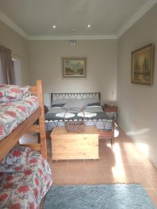 a bedroom with two beds and a wooden table at Royal Karoo Cottage in Beaufort West