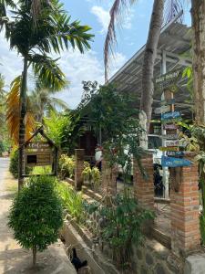 a store on the side of a street with palm trees at Didu's Homestay Bed & Breakfast in Banyuwangi