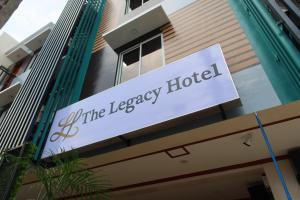 um sinal para o hotel legado do lado de um edifício em The Legacy Hotel em Tayabas