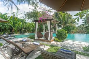 eine Terrasse mit einem Pavillon neben einem Pool in der Unterkunft Manah Shanti Suites by Pramana Villas in Ubud