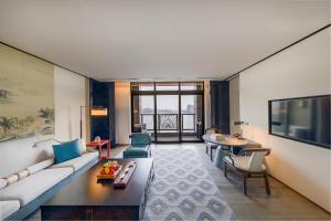 a living room with a couch and a table at JiuTai Hotel Hangzhou in Hangzhou
