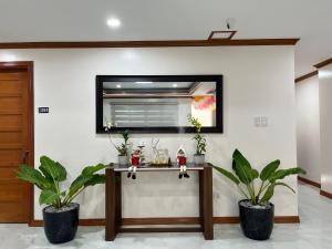 une table dans une pièce avec deux plantes en pot dans l'établissement The Legacy Hotel, à Tayabas