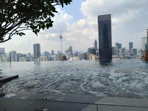 a swimming pool on the roof of a building with a city at KLCC Suites At Axon Residence in Kuala Lumpur