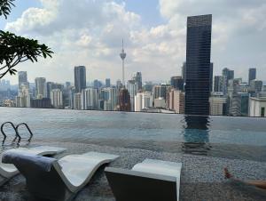 a swimming pool with a view of a city at KLCC Suites At Axon Residence in Kuala Lumpur