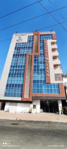 a large building with blue windows on a street at Hotel Imolesh Imphal in Imphal