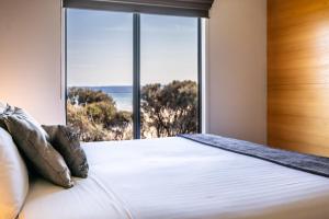 1 dormitorio con 1 cama y vistas al océano en Footprints 2, en Coles Bay