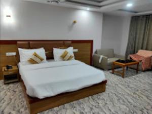 - une chambre avec un grand lit blanc et un canapé dans l'établissement Hotel Imolesh Imphal, à Imphal