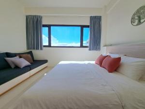 a bedroom with a large bed and a couch at Sunrise Inari B&B in Dongshan