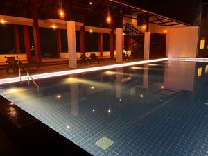 a large swimming pool with lights in a building at Niraamaya Retreats Vaidekam, Kannur in Kannur
