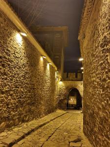 an alley with a stone wall at night with lights at HANCHO - OLD TOWN CENTER PLOVDIV in Plovdiv