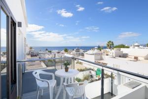 balcón con mesa, sillas y vistas al océano en APARTMENT TIMPLE Puerto del Carmen, en Puerto del Carmen