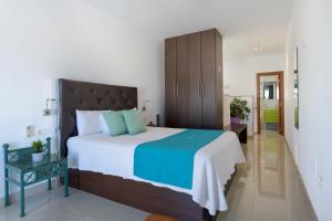 Schlafzimmer mit einem großen Bett mit einem Kopfteil aus Holz in der Unterkunft APARTMENT TIMPLE Puerto del Carmen in Puerto del Carmen