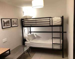 a room with two bunk beds and a glass table at IPOH 8Perkins Canning Garden 7-8pax Elegant Homestay with 4Bedrooms, 3Bathroom, 1Living, 1Dining, 1Kitchen-Bar with 3Parkings in Ipoh