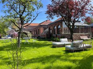 a green yard with two couches in front of a building at LA PARCELLE in Lezennes