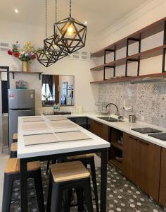 a kitchen with a table with stools in it at IPOH 8Perkins Canning Garden 7-8pax Elegant Homestay with 4Bedrooms, 3Bathroom, 1Living, 1Dining, 1Kitchen-Bar with 3Parkings in Ipoh