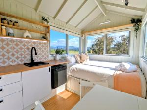 una piccola cucina con due letti in una casetta di Warburton Tiny House - Tiny Stays a Yarra Junction