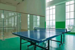 a blue ping pong table in a room with windows at Lovely 3-Bedroom rental unit in Jakarta