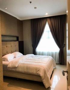a bedroom with a large bed and a window at Lovely 3-Bedroom rental unit in Jakarta