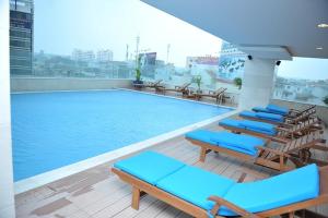 a swimming pool with blue lounge chairs on a building at Vissai Saigon Hotel in Ho Chi Minh City