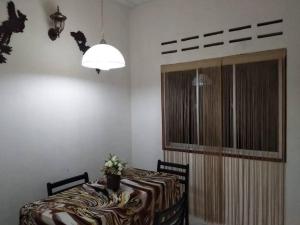 une salle à manger avec une table et une lampe dans l'établissement Homestay Dahlia, à Teluk Intan