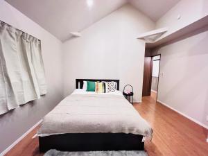 a bedroom with a large bed in a white room at Zaki-House in Tokyo