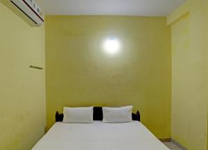 um quarto com uma cama com duas almofadas brancas em OYO Hotel RS Guest House em Katni