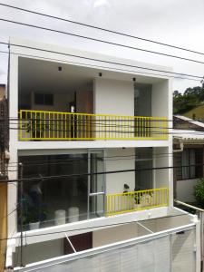 un edificio con un balcón amarillo encima en ROZA apartaments & suits, en Loja