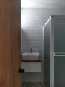 uma casa de banho com um lavatório branco e um espelho. em ROZA apartaments & suits em Loja