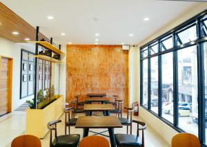 a restaurant with tables and chairs and windows at Travelbee Airport Inn in Mactan