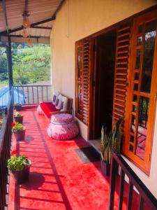 a balcony of a house with a red rug at Vegetable Garden House in Adams Peak