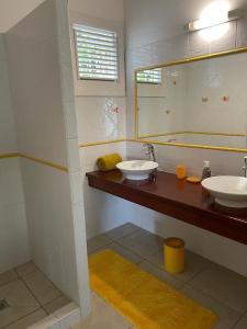 a bathroom with two sinks and a mirror at Villa Akaz in Le Robert