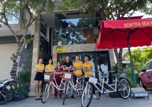 a group of people in yellow shirts standing next to their bikes at Sontra Sea Hotel in Danang