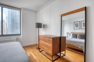 a bedroom with a mirror and a bed at Midtown 1BR w Water views Indoor pool NYC-36 in New York
