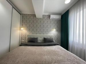 1 dormitorio con 1 cama y cortina verde en Комфортабельная квартира на улице Василе Лупу en Chişinău