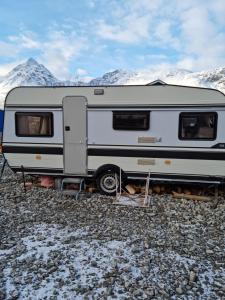 un rimorchio bianco parcheggiato di fronte a una montagna di Captains` Sea side 