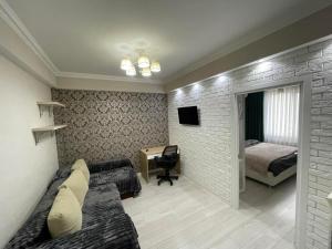a bedroom with a couch and a bed and a desk at Комфортабельная квартира на улице Василе Лупу in Chişinău