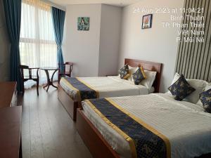 een hotelkamer met 2 bedden en een tafel bij Căn hộ biển APEC MANDALA mũi né in Phan Thiet