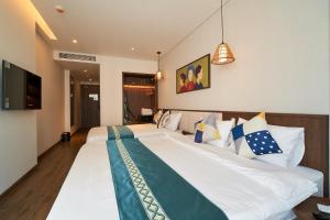 een slaapkamer met een groot wit bed met kussens bij Căn hộ biển APEC MANDALA mũi né in Phan Thiet
