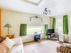 sala de estar con cortinas verdes y sofá en Secluded Holiday Home in Ceredigion with Garden, en Pennant