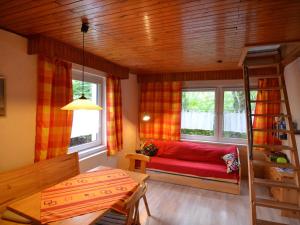 ベースコーにあるCozy Holiday Home in Brandenburg near Lakeのリビングルーム(赤いソファ、窓2つ付)