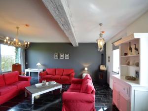 a living room with red couches and a table at Attractive Holiday Home in Gerin near centre in Gerin